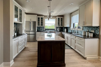 Bild på ett mellanstort funkis brun brunt kök, med en undermonterad diskho, skåp i shakerstil, turkosa skåp, bänkskiva i kvartsit, flerfärgad stänkskydd, stänkskydd i mosaik, rostfria vitvaror, vinylgolv, en köksö och beiget golv