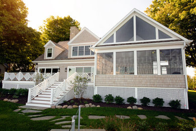 Inspiration for a beige two-story wood exterior home remodel in Other with a shingle roof
