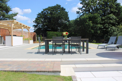 Inspiration for a large contemporary back rectangular above ground swimming pool in Essex with with pool landscaping and decking.