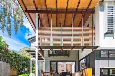 Design ideas for a contemporary two-storey white house exterior in Brisbane with a shed roof.