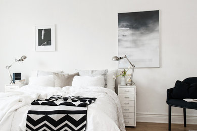 Photo of a mid-sized scandinavian master bedroom in Gothenburg with white walls, medium hardwood floors and no fireplace.