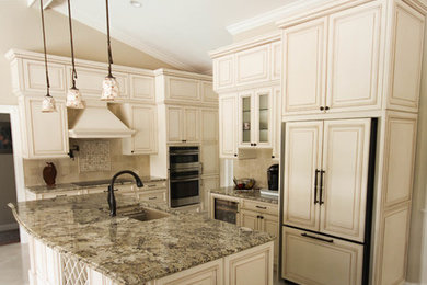 Mid-sized elegant travertine floor eat-in kitchen photo in Miami with a double-bowl sink, granite countertops, beige backsplash, stone tile backsplash, paneled appliances and an island