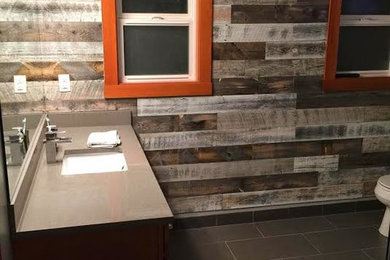 Inspiration for a mid-sized rustic 3/4 porcelain tile bathroom remodel in New York with a one-piece toilet, multicolored walls, an undermount sink and solid surface countertops