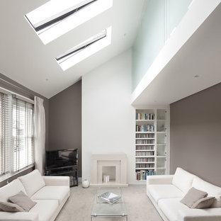 Bild på ett funkis allrum med öppen planlösning, med grå väggar, heltäckningsmatta, en standard öppen spis, en spiselkrans i sten och en fristående TV