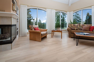 Elegant open concept beige floor living room photo in Vancouver with beige walls, a two-sided fireplace, a tile fireplace and no tv