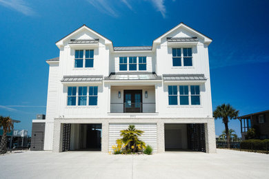 Large beach style white three-story mixed siding and board and batten house exterior photo in Charleston with a metal roof and a gray roof
