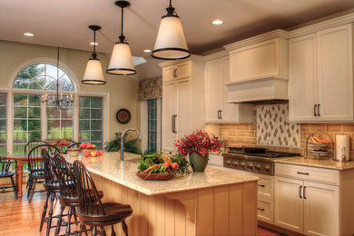 Inspiration for a timeless galley medium tone wood floor and brown floor kitchen remodel in Philadelphia with an undermount sink, recessed-panel cabinets, beige cabinets, brown backsplash, subway tile backsplash, stainless steel appliances, an island and brown countertops