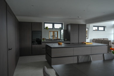 Large modern kitchen/diner in Other with flat-panel cabinets, black cabinets and an island.