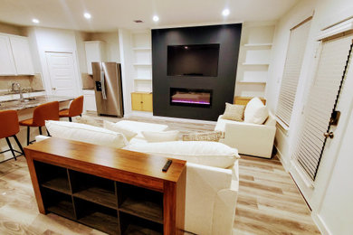 Living room - mid-sized contemporary open concept vinyl floor and brown floor living room idea in Houston with black walls, a hanging fireplace, a plaster fireplace and a media wall