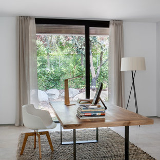 Inspiration for a medium sized modern study in Madrid with a freestanding desk, white walls, carpet and no fireplace.