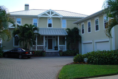 Inspiration for a large traditional two-storey yellow exterior in Tampa with vinyl siding.