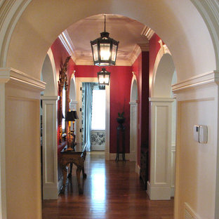 Foto på en mellanstor vintage hall, med röda väggar och mellanmörkt trägolv
