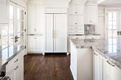 Large elegant l-shaped dark wood floor eat-in kitchen photo in Salt Lake City with a farmhouse sink, beaded inset cabinets, white cabinets, marble countertops, white backsplash, stone slab backsplash, paneled appliances and an island
