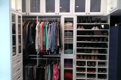 Large elegant gender-neutral medium tone wood floor dressing room photo in Raleigh with white cabinets