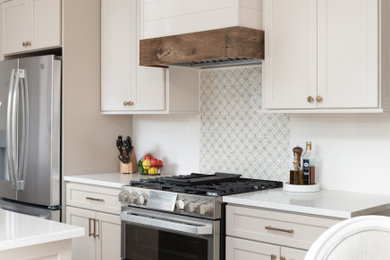 Eat-in kitchen - small traditional galley medium tone wood floor and brown floor eat-in kitchen idea in Chicago with a farmhouse sink, flat-panel cabinets, white cabinets, quartz countertops, white backsplash, ceramic backsplash, stainless steel appliances, an island and white countertops