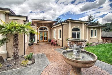 Inspiration for a huge mediterranean beige stucco exterior home remodel in Seattle with a hip roof