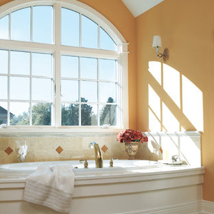 Idee per una grande stanza da bagno padronale moderna con vasca ad angolo, pareti arancioni, piastrelle beige e piastrelle in terracotta