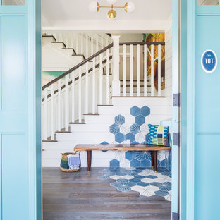 Idee per una porta d'ingresso stile marino di medie dimensioni con pareti bianche, pavimento in legno massello medio, una porta olandese, una porta blu e pavimento marrone