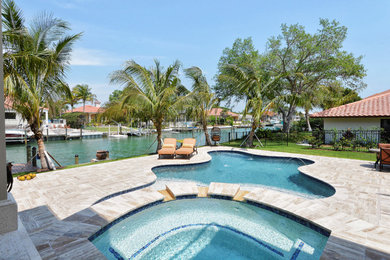 Inspiration for a transitional custom-shaped pool in Tampa with a hot tub and tile.