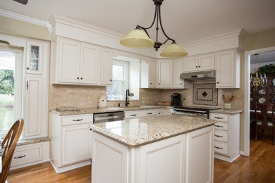 Eat-in kitchen - mid-sized transitional l-shaped medium tone wood floor eat-in kitchen idea in Other with white cabinets, granite countertops, beige backsplash, stone tile backsplash, stainless steel appliances, an island, shaker cabinets and a double-bowl sink