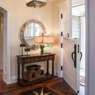 Выдающиеся фото от архитекторов и дизайнеров интерьера: фойе в морском стиле с бежевыми стенами, темным паркетным полом, голландской входной дверью и белой входной дверью