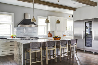 Example of a transitional l-shaped dark wood floor kitchen design in Chicago with shaker cabinets, white cabinets, gray backsplash, stainless steel appliances, an island and gray countertops