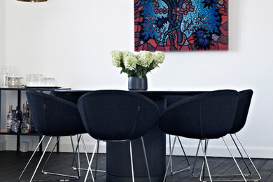Photo of a mid-sized contemporary separate dining room in Other with white walls, painted wood floors and black floor.