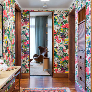 Inredning av en eklektisk hall, med flerfärgade väggar och mellanmörkt trägolv