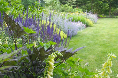 Photo of a mid-sized traditional full sun backyard stone landscaping in Boston.