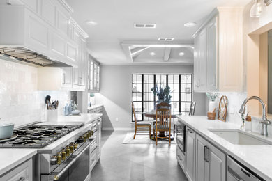Example of a mid-sized transitional galley eat-in kitchen design in Dallas with an undermount sink, raised-panel cabinets, white cabinets, quartz countertops, white backsplash, stainless steel appliances, no island and white countertops