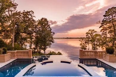 Example of a tuscan backyard custom-shaped infinity pool design in Other