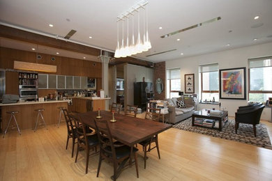 Example of a mid-sized trendy light wood floor great room design in New York with white walls and no fireplace