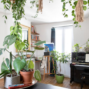 Photo of a small mediterranean open plan living room in Paris with a music area, white walls, medium hardwood flooring, no fireplace, no tv and brown floors.