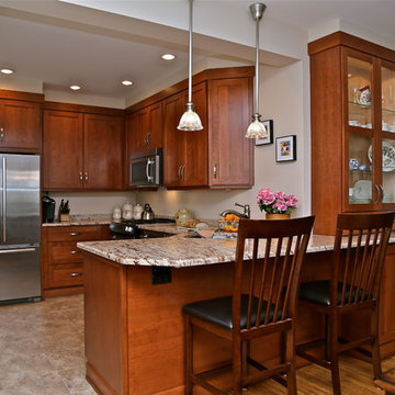 Warm Wood Kitchen Remodel | Angled Granite Island & Integrated Display Cabinets
