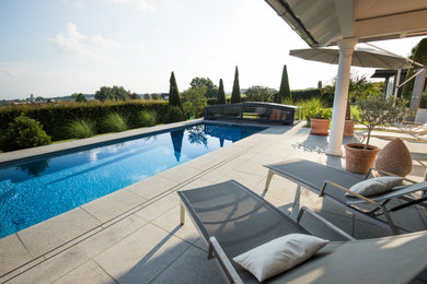 Großer Moderner Pool neben dem Haus in rechteckiger Form mit Natursteinplatten in München