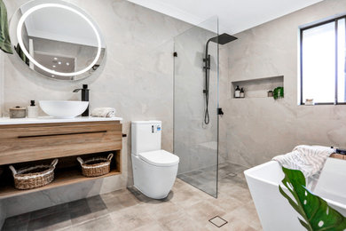 Photo of a mid-sized contemporary master bathroom in Sydney with light wood cabinets, a freestanding tub, a corner shower, a two-piece toilet, gray tile, marble, beige walls, ceramic floors, a vessel sink, engineered quartz benchtops, grey floor, an open shower, white benchtops, a niche, a single vanity and a floating vanity.