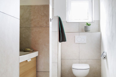 Kleines Modernes Duschbad mit hellbraunen Holzschränken, beigen Fliesen, Mineralwerkstoff-Waschtisch, Einzelwaschbecken und schwebendem Waschtisch in Köln