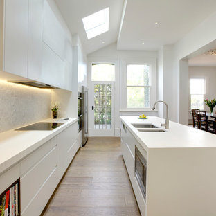 Пример оригинального дизайна: большая линейная кухня в современном стиле с кладовкой, двойной раковиной, фасадами с декоративным кантом, белыми фасадами, столешницей из ламината, фартуком из каменной плиты, техникой из нержавеющей стали и островом