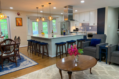 Example of a mid-sized trendy l-shaped medium tone wood floor eat-in kitchen design in DC Metro with shaker cabinets, blue cabinets, quartzite countertops, blue backsplash, an island, white countertops, a farmhouse sink, ceramic backsplash and stainless steel appliances