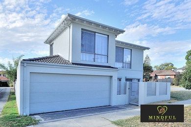 This is an example of a mid-sized modern two-storey brick white duplex exterior in Perth with a hip roof and a tile roof.