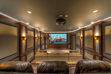 This is an example of a large traditional enclosed home theatre in Miami with grey walls, medium hardwood floors, a projector screen and multi-coloured floor.