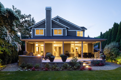 This is an example of a mid-sized transitional back porch design in Seattle with a roof extension.