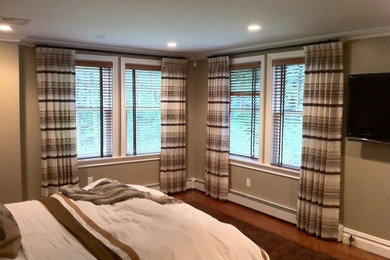 Mid-sized transitional master medium tone wood floor and brown floor bedroom photo in New York with beige walls