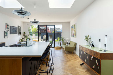 Design ideas for an expansive retro kitchen/dining room in Hampshire with white walls, medium hardwood flooring and beige floors.