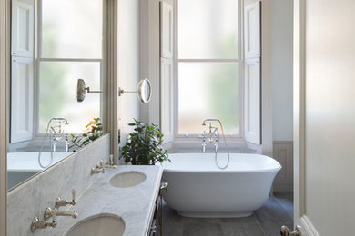 Photo of a traditional kids bathroom in London with a freestanding tub, ceramic tile, ceramic floors and marble benchtops.