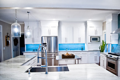 Mid-sized trendy l-shaped dark wood floor and brown floor open concept kitchen photo in Atlanta with a farmhouse sink, shaker cabinets, white cabinets, quartz countertops, blue backsplash, glass tile backsplash, stainless steel appliances and an island