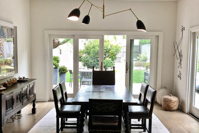 Inspiration for a large contemporary separate dining room in Los Angeles with white walls, medium hardwood floors, no fireplace and brown floor.