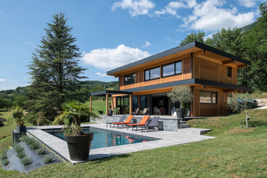 Dreistöckiges Haus mit brauner Fassadenfarbe, Flachdach und Wandpaneelen in Grenoble