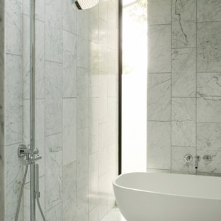 Foto di una stanza da bagno minimalista con vasca freestanding, zona vasca/doccia separata, piastrelle bianche, pareti bianche, pavimento bianco e doccia aperta