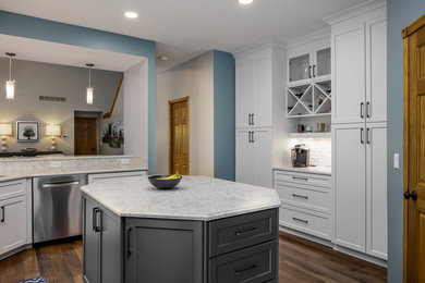 Eat-in kitchen - brown floor eat-in kitchen idea in Other with white cabinets, white backsplash and an island